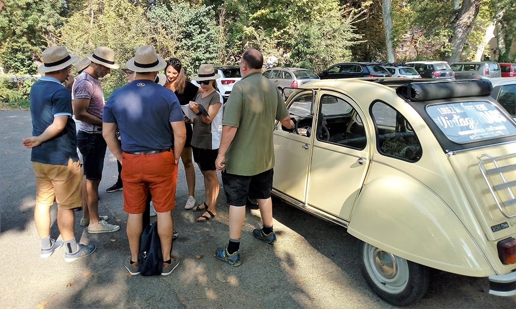 Personnes se tenant debout devant une 2CV