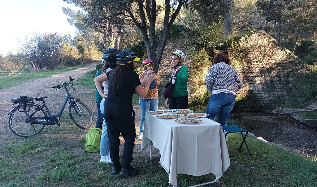 6 personnes s'accordant une pause au bord d'un sentier après une excursion en vélo
